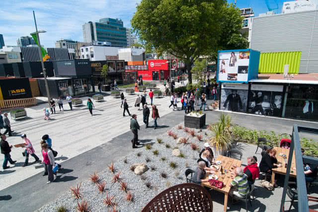 City centre surrounded by buildings and filled with people walking around