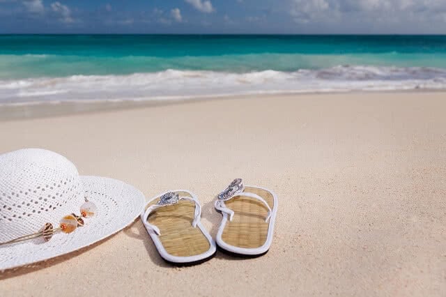 Hat and flip flops on the beach