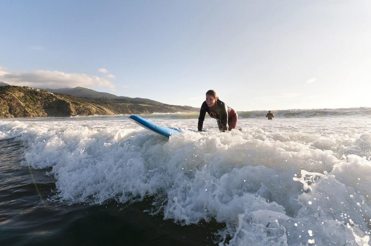 Young lady surfing at Raglan