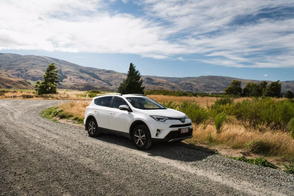 car on gravel road with landscape background