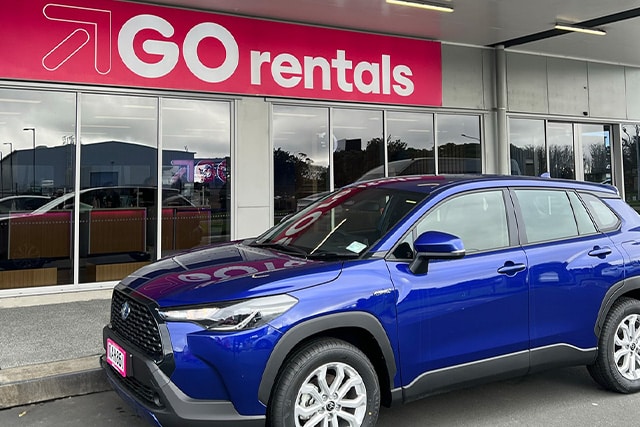 Toyota Corolla Cross Hybrid in front of GO Rentals New Zealand branch